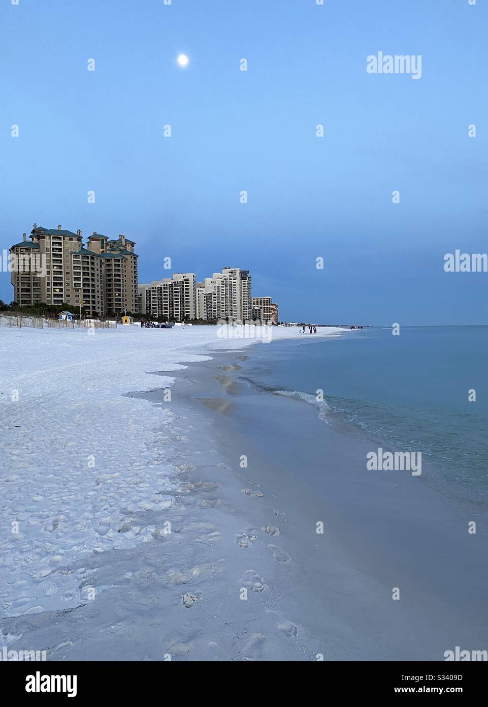 Full moon shining bright as sunset begins on the beach - Smartphone Captured Stock Image
