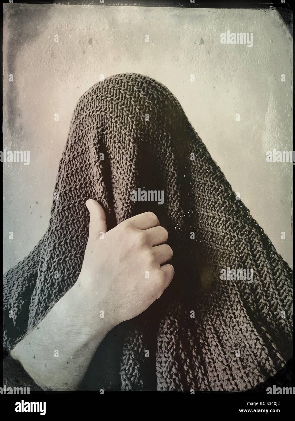 Man covers his face with a wool blanket - Smartphone Captured Stock Image