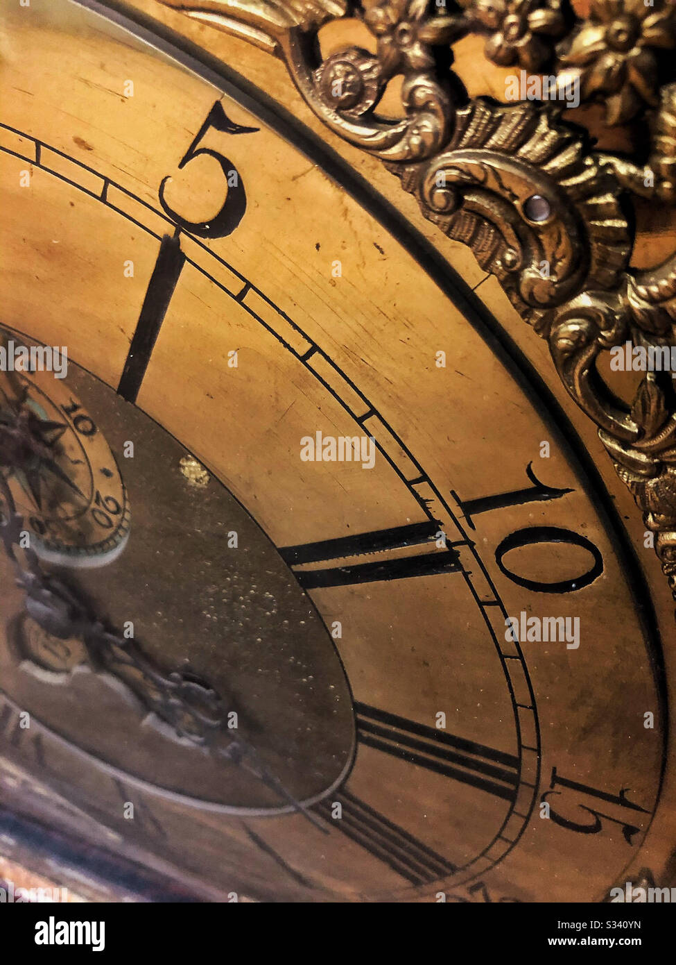 Antique clock face with hand-etched numbers on decorative metal face - Smartphone Captured Stock Image
