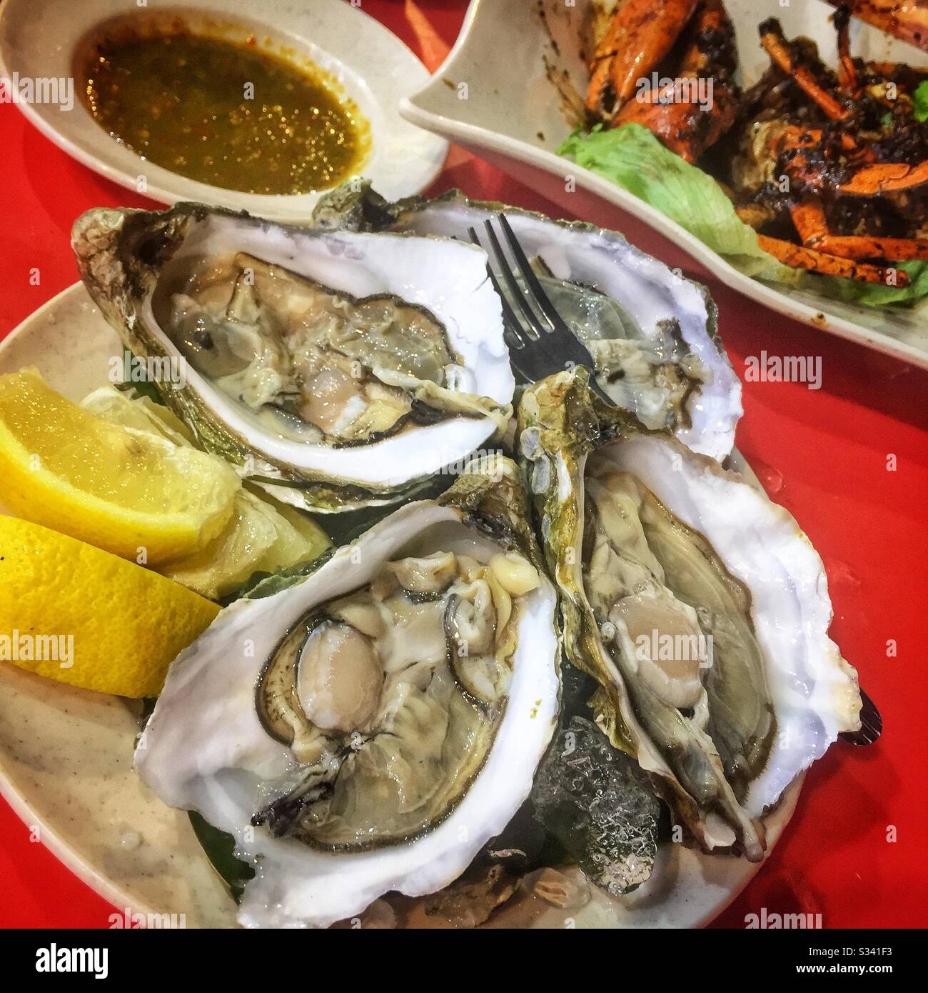 Oysters in a street restaurant in Jalan Alor, a hawker food market in Bukit Bintang, Kuala Lumpur, Malaysia - Smartphone Captured Stock Image