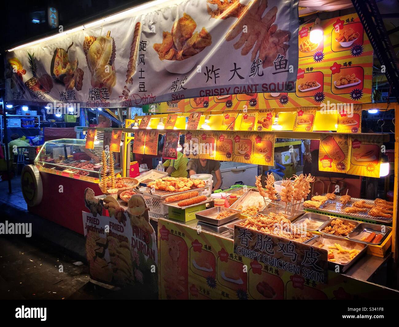 A food stall sells a selection of fried food in Jalan Alor, a hawker food market in Bukit Bintang, Kuala Lumpur, Malaysia - Smartphone Captured Stock Image