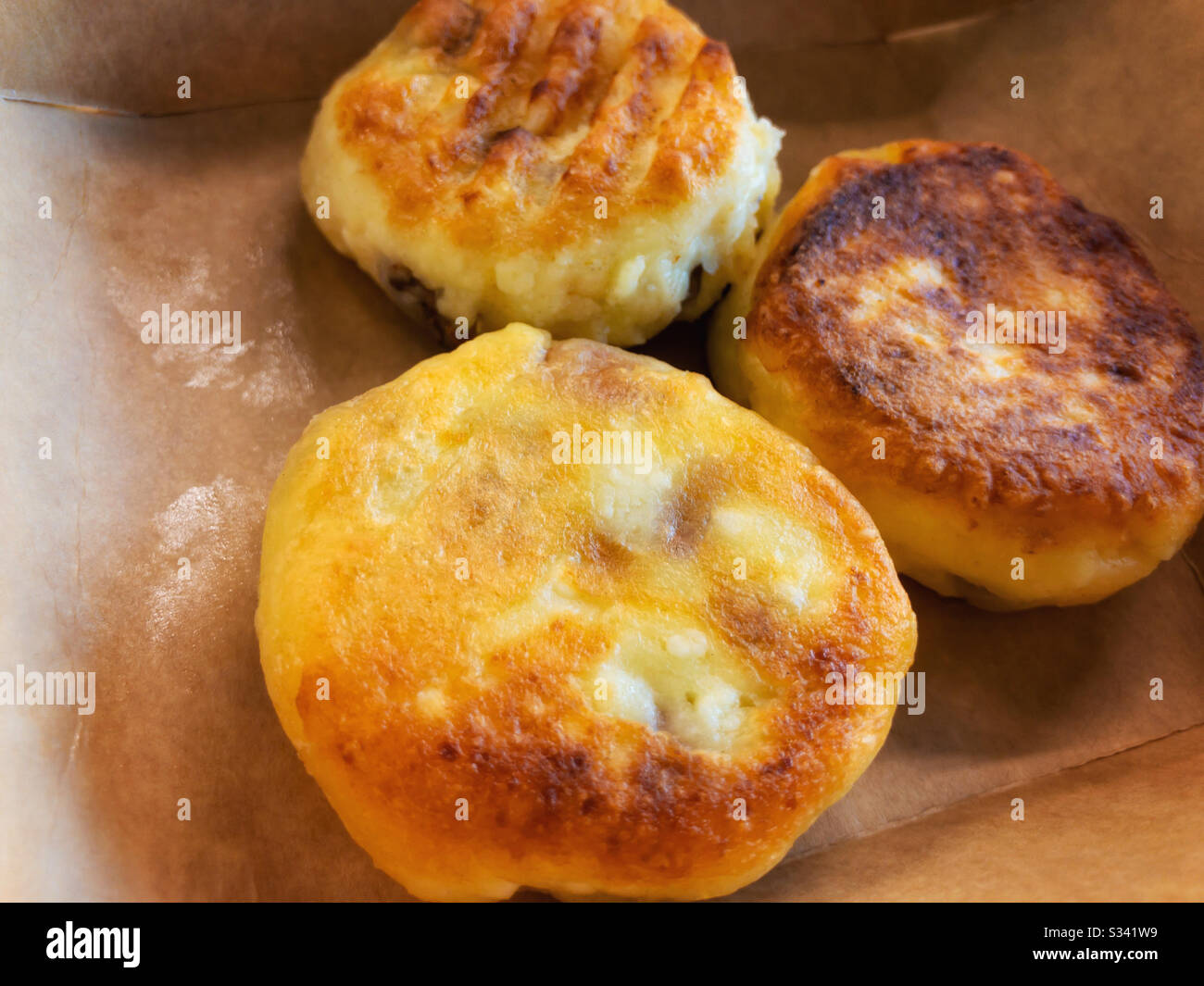 Close view on cheese pancakes lying in opened paper box Stock Photo