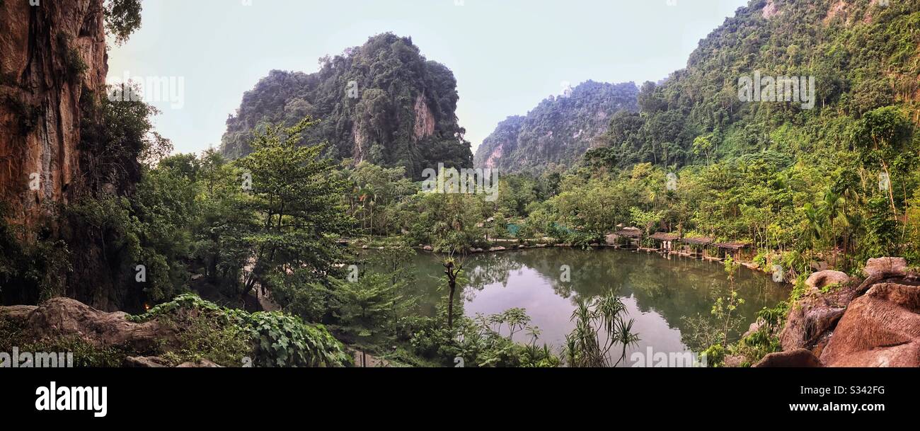 The view from the SkyBar at The Banjaran Hotsprings Retreat, overlooking a man-made lake fed by geothermal hotsprings and the spectacular limestone karst landscape near Ipoh, Malaysia - Smartphone Captured Stock Image