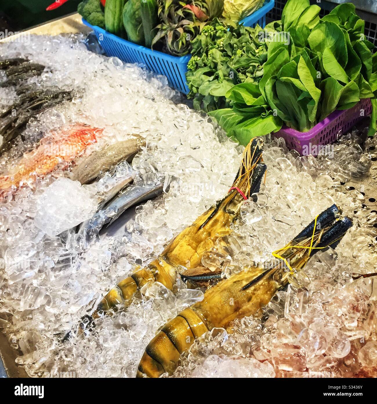 Fish, prawns and vegetables for sale at a street restaurant in Jalan Alor, a hawker food market in Bukit Bintang, Kuala Lumpur, Malaysia - Smartphone Captured Stock Image