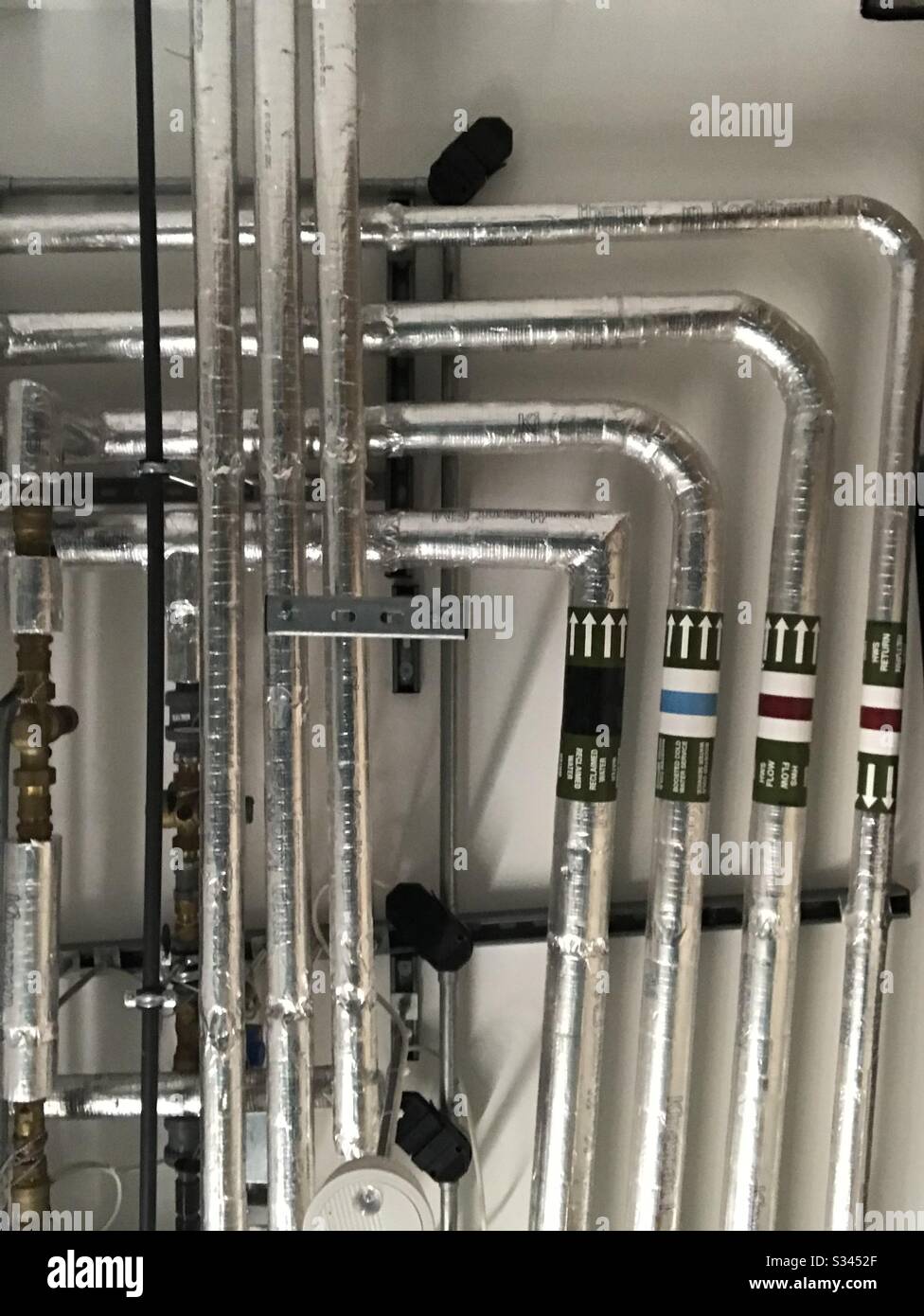 Silver aluminium selection of water heating pipes attached to ceiling - Smartphone Captured Stock Image