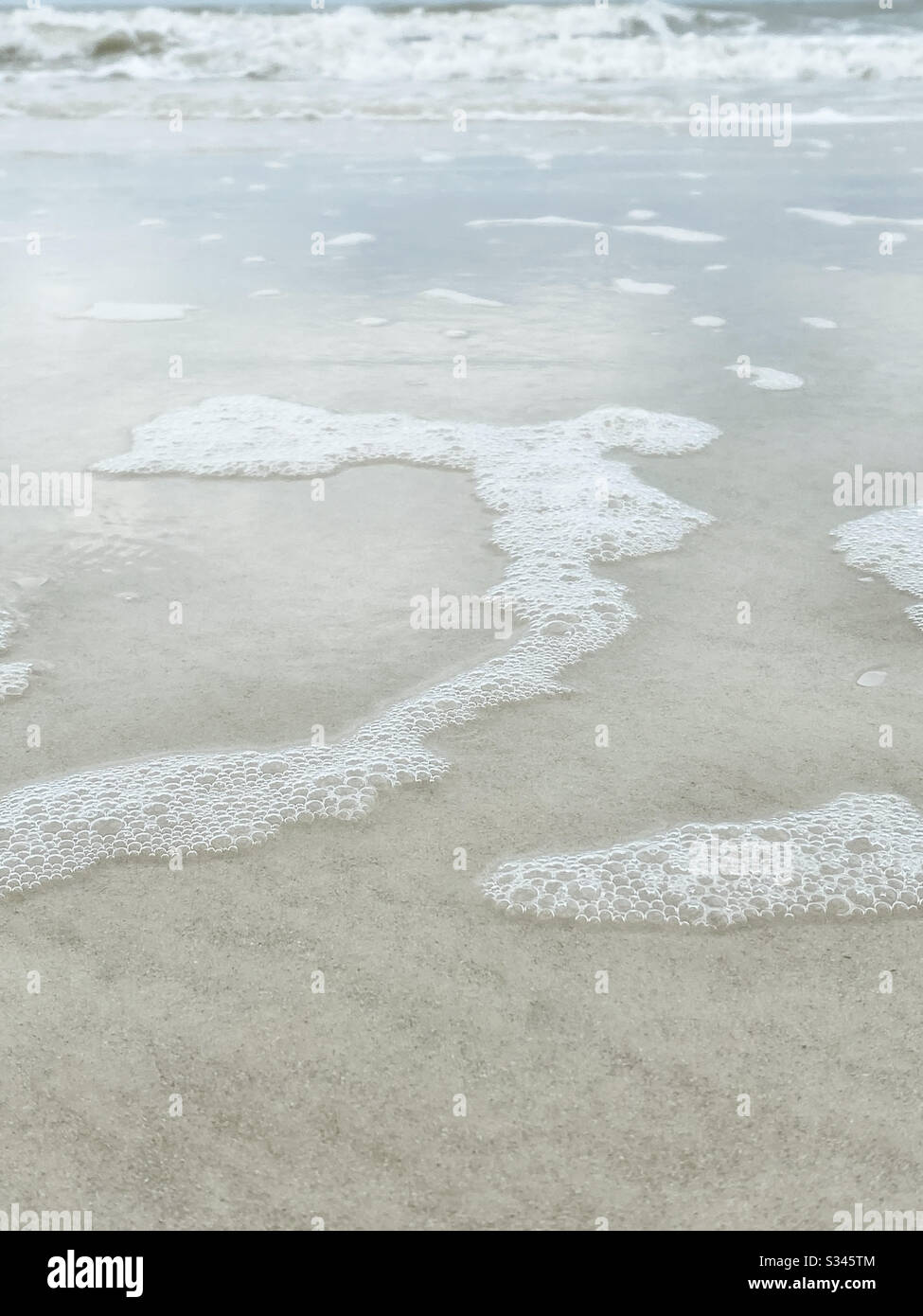Low angle of beach and sea foam - Smartphone Captured Stock Image