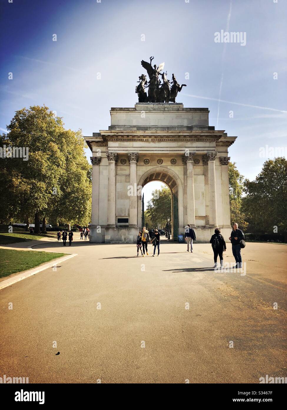 A scenic view of tourists standing by Wellington Arch, London during early autumn - Smartphone Captured Stock Image