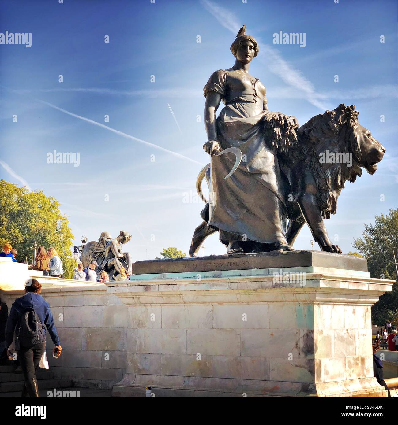 A close up shot of the Agriculture statue at one of the corners of the Victoria Memorial, The Mall, London. Under a blue sky with plane vapour trails - Smartphone Captured Stock Image