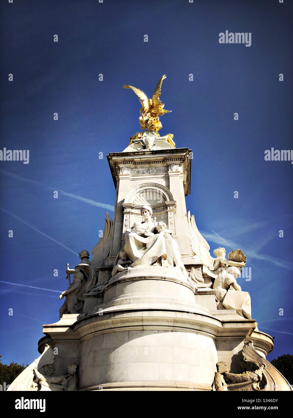 A close up shot of the Victoria Memorial, The Mall, London. Beneath a colourful blue sky with airplane contrails - Smartphone Captured Stock Image