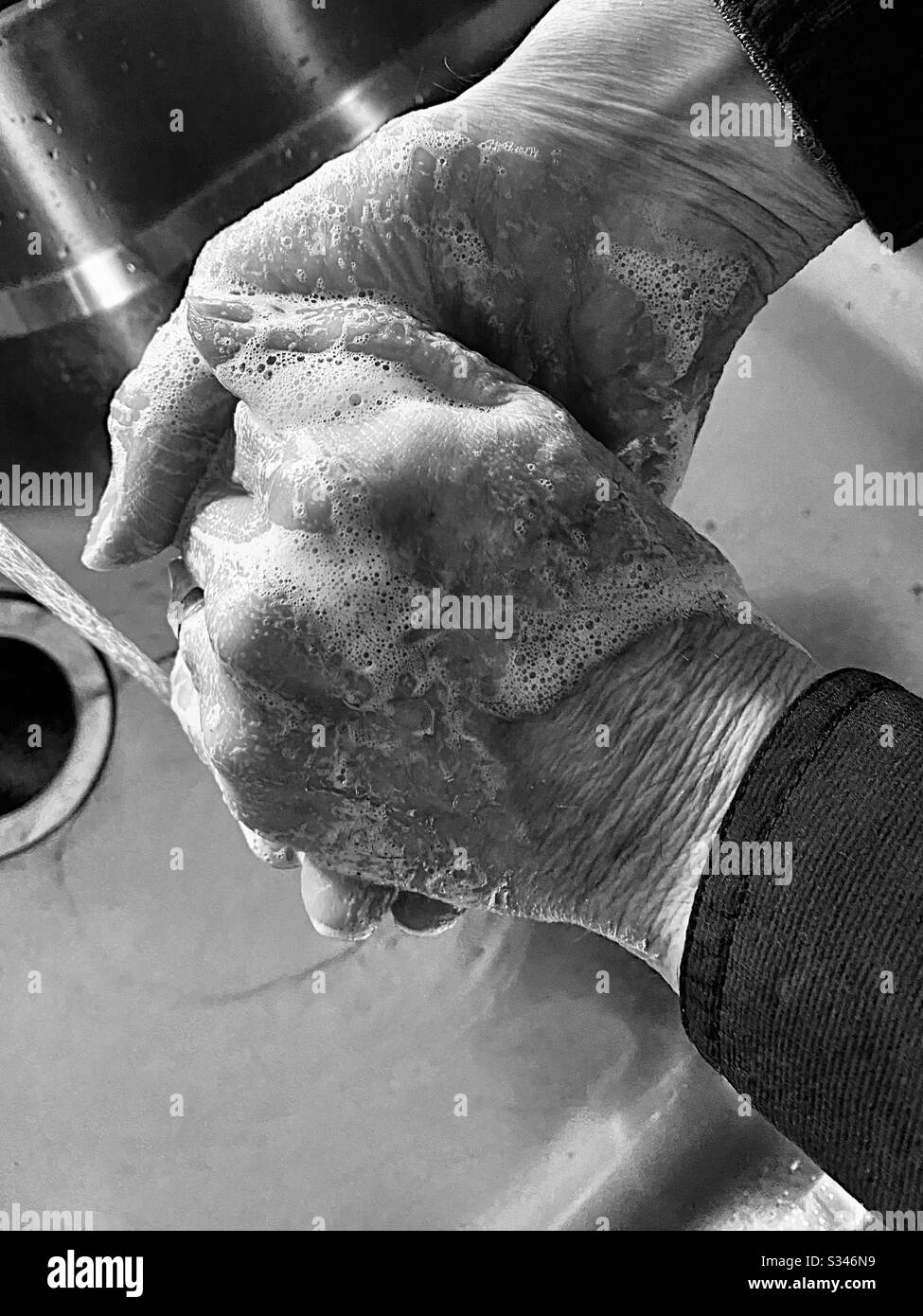 Man washing hands, black and white - Smartphone Captured Stock Image