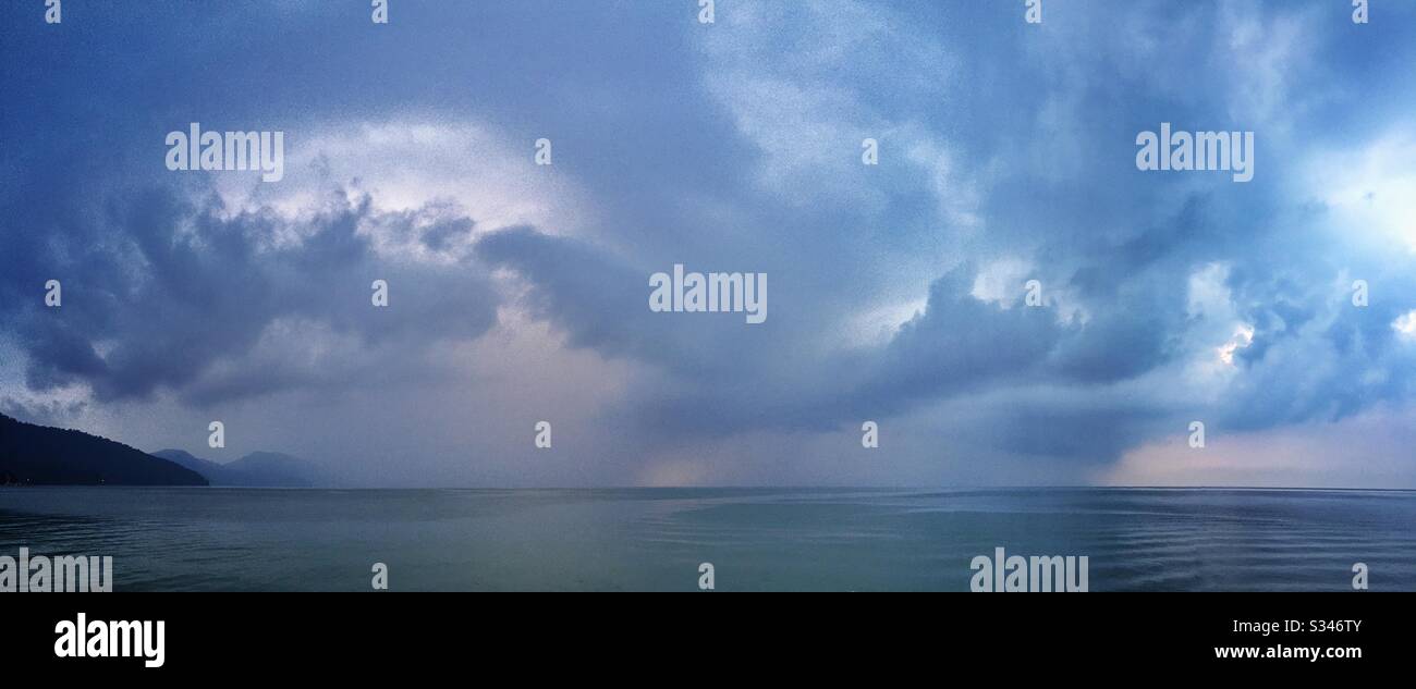 A morning rain squall over the ocean at Batu Ferringhi, Penang, Malaysia - Smartphone Captured Stock Image