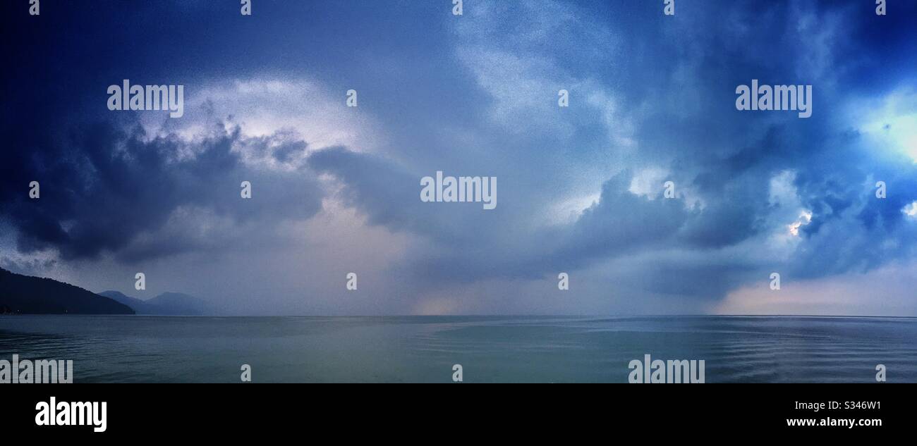 A morning rain squall over the ocean at Batu Ferringhi, Penang, Malaysia - Smartphone Captured Stock Image