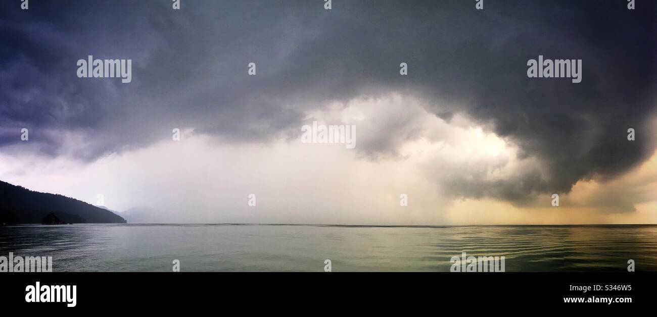 A morning rain squall over the ocean at Batu Ferringhi, Penang, Malaysia - Smartphone Captured Stock Image
