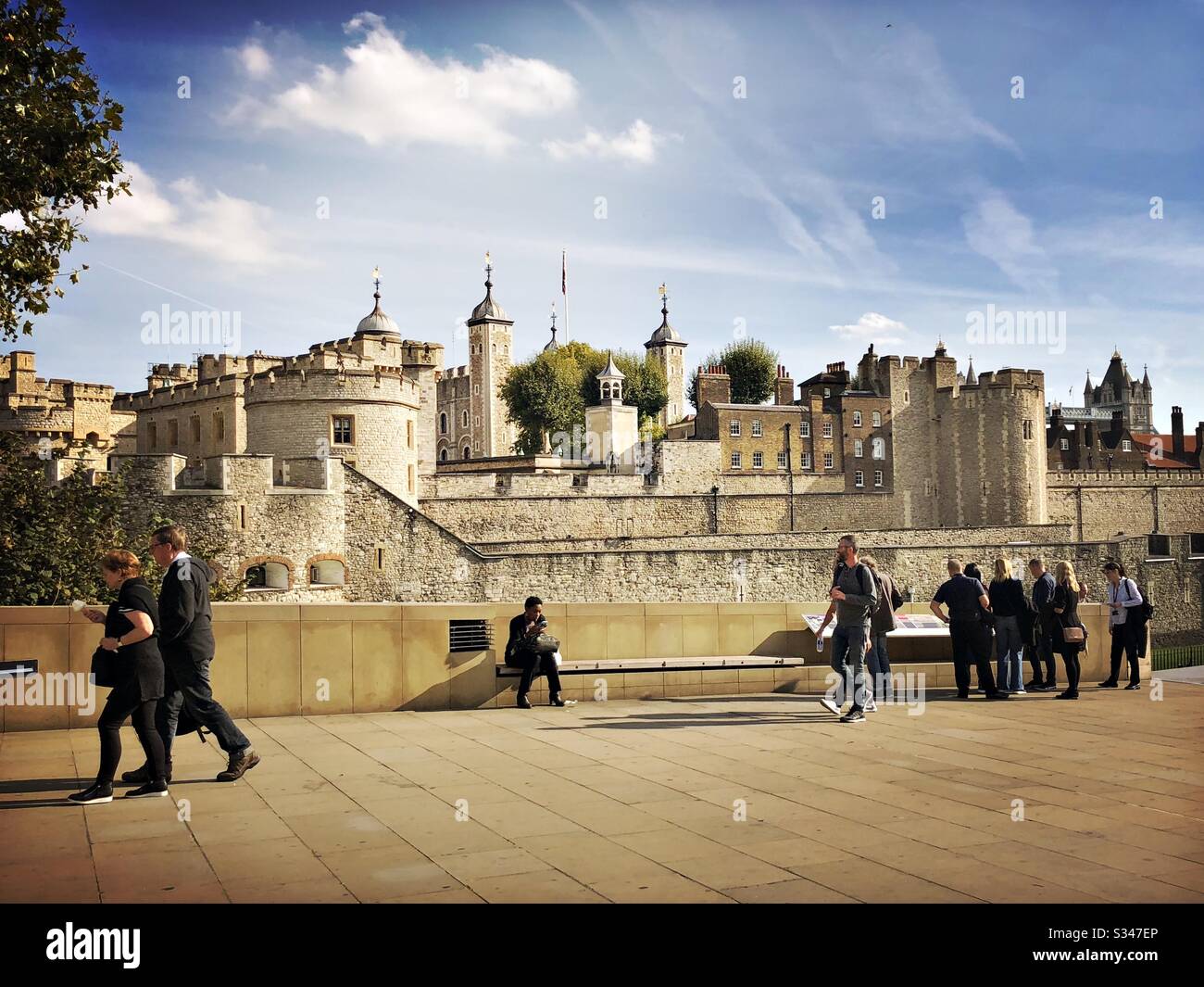 Pedestrians near the entrance to Tower of London. Historic castle and fortress complex within Tower Hamlets. UNESCO World Heritage Site - Smartphone Captured Stock Image