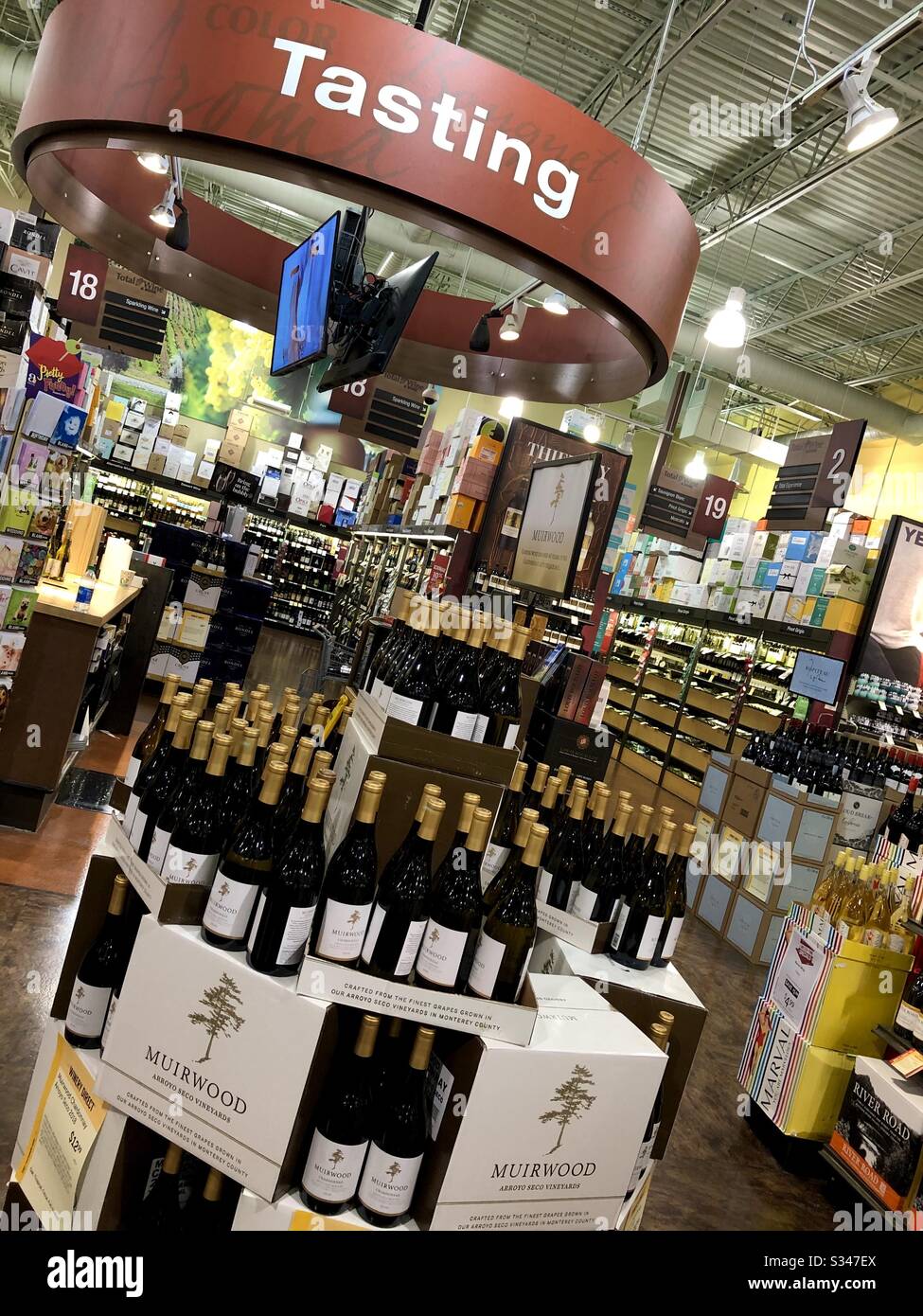 Wine tasting display in an upscale liquor store showing a variety of wines with a security video screen in Florida, USA. - Smartphone Captured Stock Image