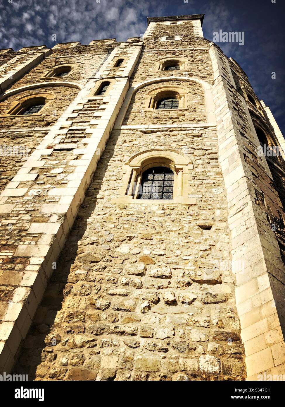A low angle view looking straight up the stone walls of the White Tower. Medieval keep within the Tower of London. Castle and fortress complex in Tower Hamlets. UNESCO World Heritage Site. - Smartphone Captured Stock Image