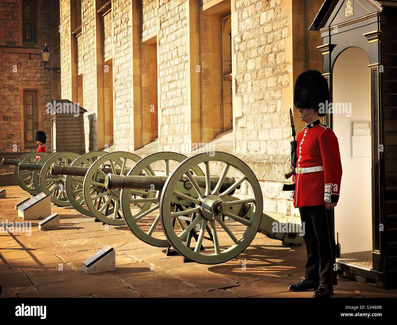 Scots Gurad sentry and royal armouries cannons stand outside the Jewel House. Location of the Crown Jewels. Waterloo Block, Tower of London. UNESCO World Heritage Site. - Smartphone Captured Stock Image