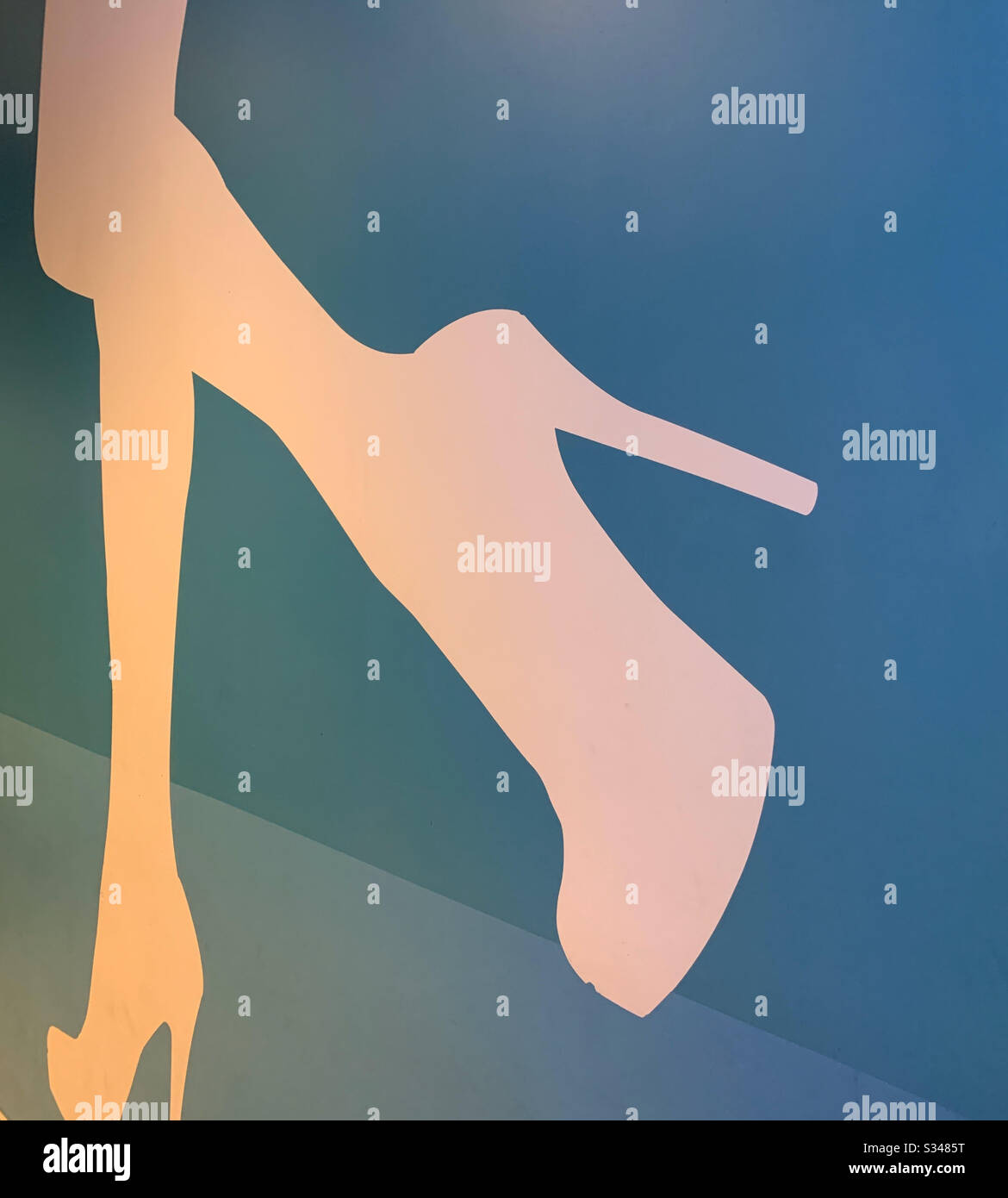 High heeled shoes and leg on a wall leading to women’s bathroom - Smartphone Captured Stock Image