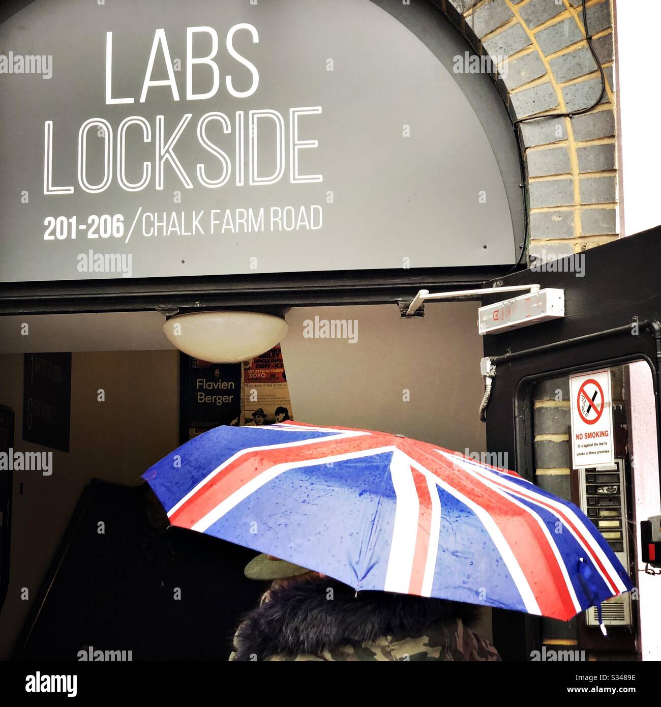 Lady with a Union Jack umbrella on the street in Camden Town, London on a rainy day - Smartphone Captured Stock Image
