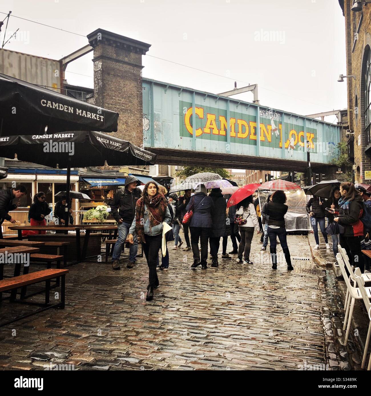 Street view at Camden Market and Camden Lock. People brave the rain in North London - Smartphone Captured Stock Image