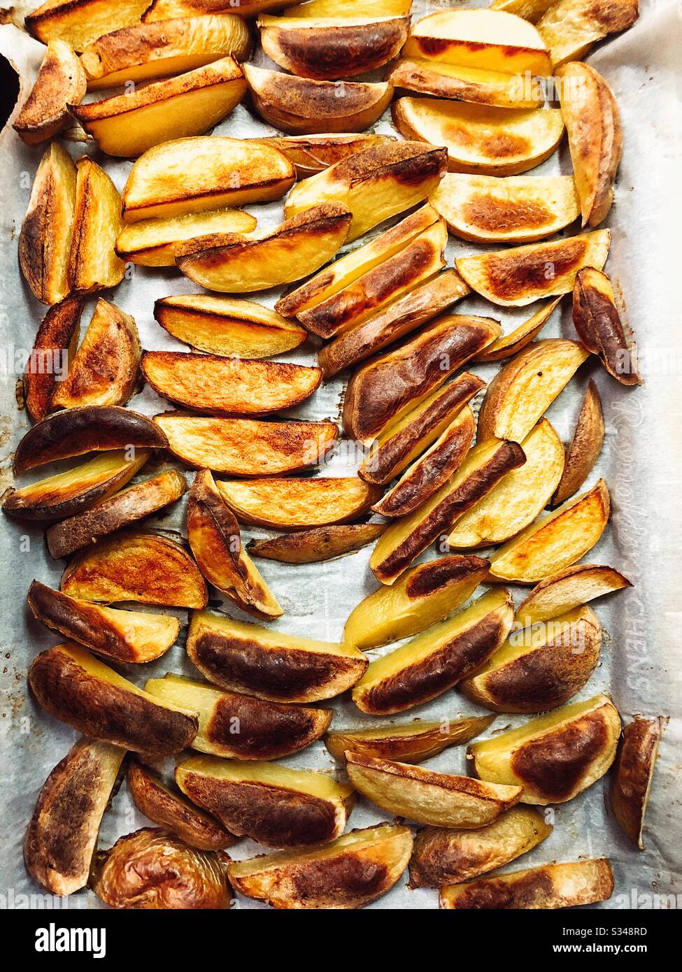 Roasted potato wedges straight from the oven Stock Photo