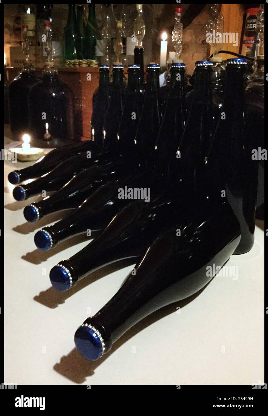Putting crown caps on sparkling wine as it enters tirage - the second fermentation that creates the bubbles - on a Syrah wine, Catalonia, Spain. - Smartphone Captured Stock Image
