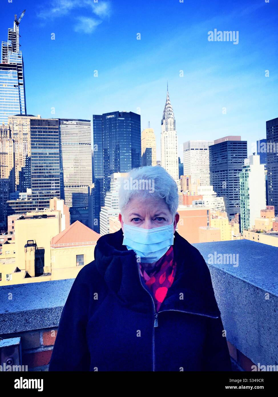 Elderly woman with health and safety concerns wears a protective facemask in midtown Manhattan during the COVID-19 pandemic, New York City, USA - Smartphone Captured Stock Image