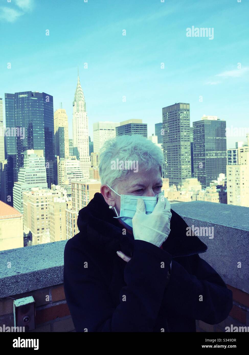 NYC COVID-19 causes an elderly woman to wear a protective mask and latex gloves to ward off germs during the outbreak, NYC, USA - Smartphone Captured Stock Image