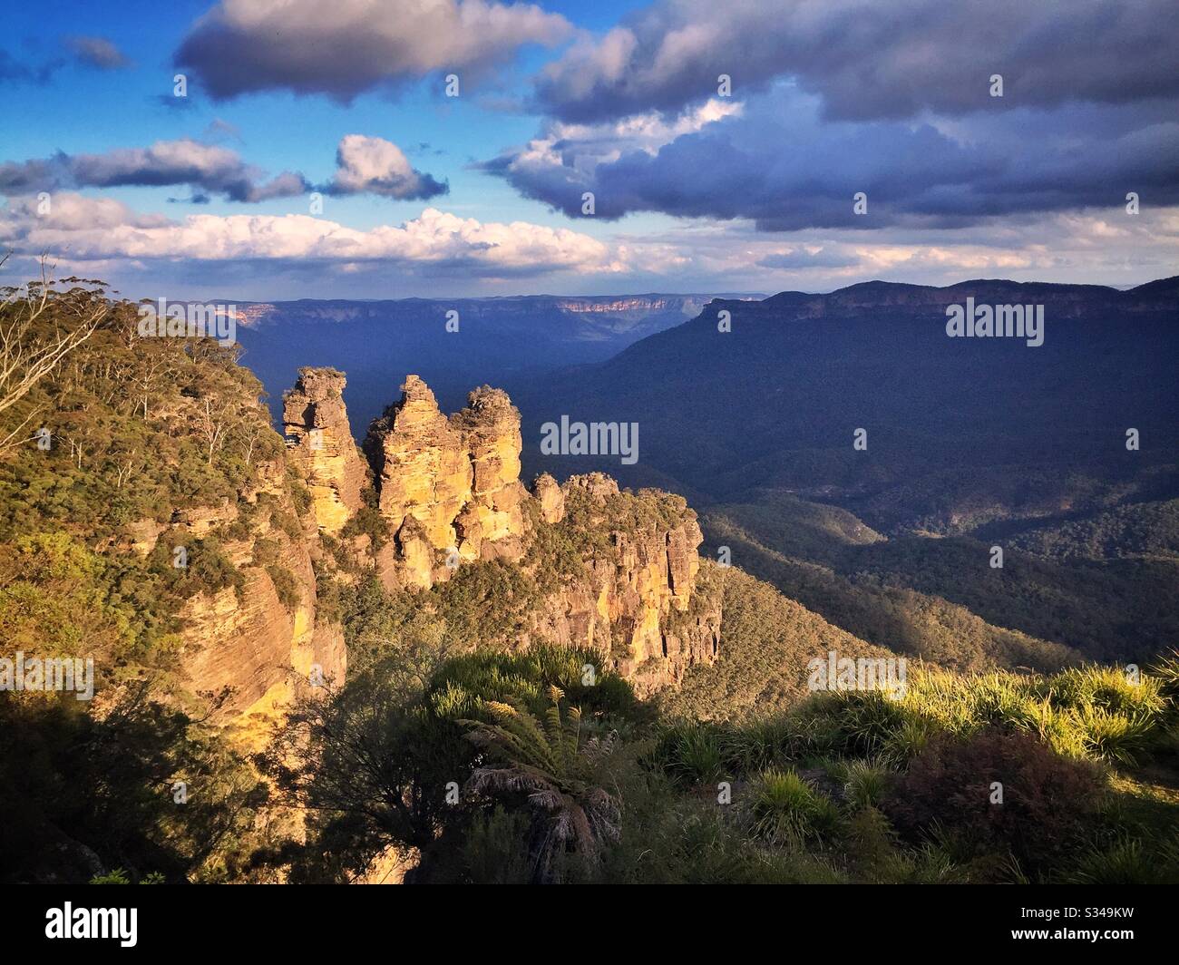 Late afternoon sunlight illuminates the Three Sisters in the Blue Mountains, National Park, NSW, Australia - Smartphone Captured Stock Image