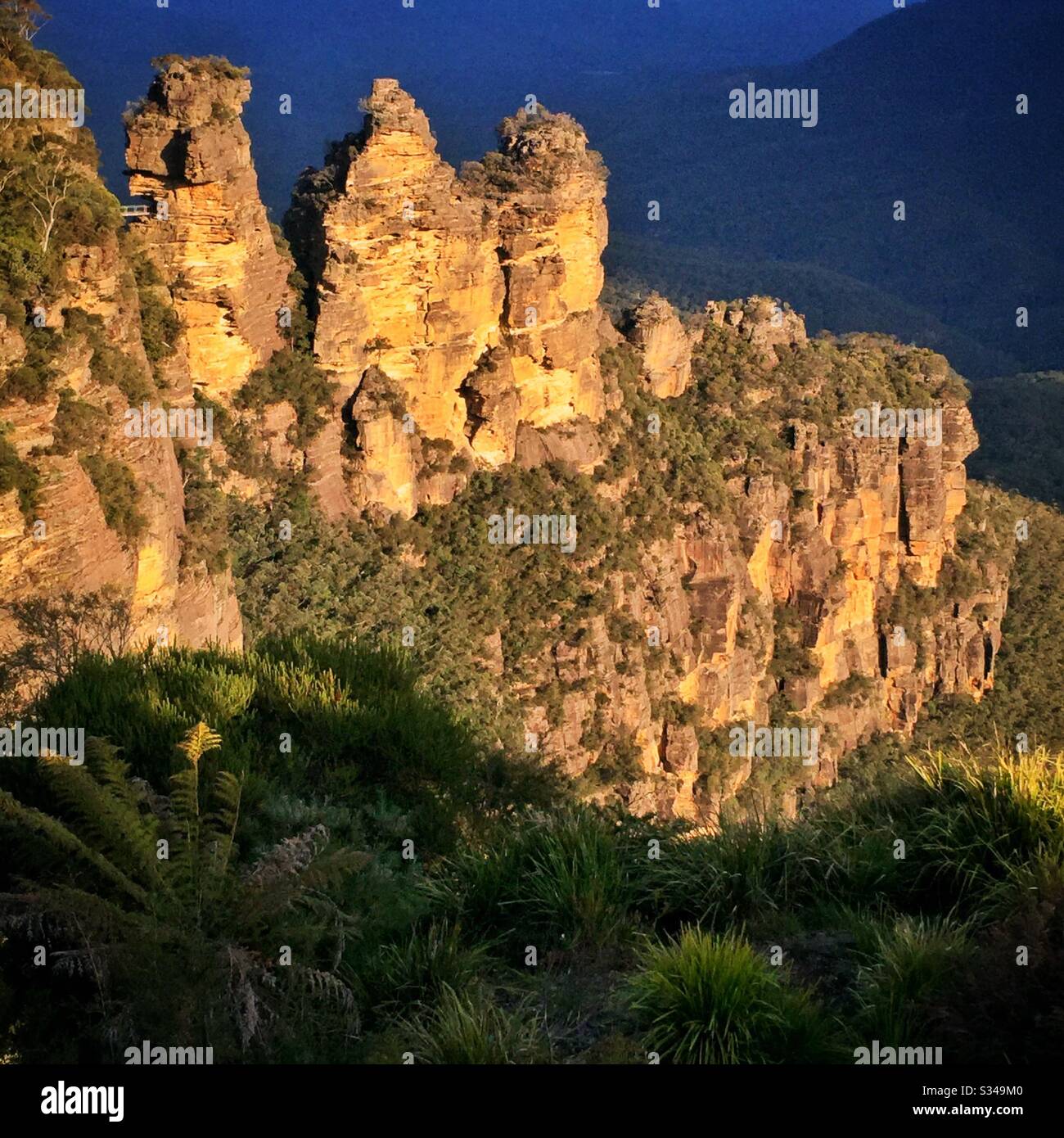 Late afternoon sunlight illuminates the Three Sisters in the Blue Mountains, National Park, NSW, Australia - Smartphone Captured Stock Image