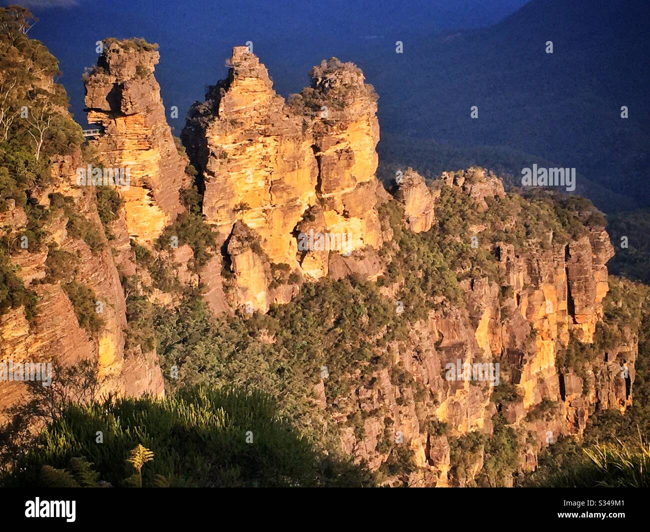 Late afternoon sunlight illuminates the Three Sisters in the Blue Mountains, National Park, NSW, Australia - Smartphone Captured Stock Image