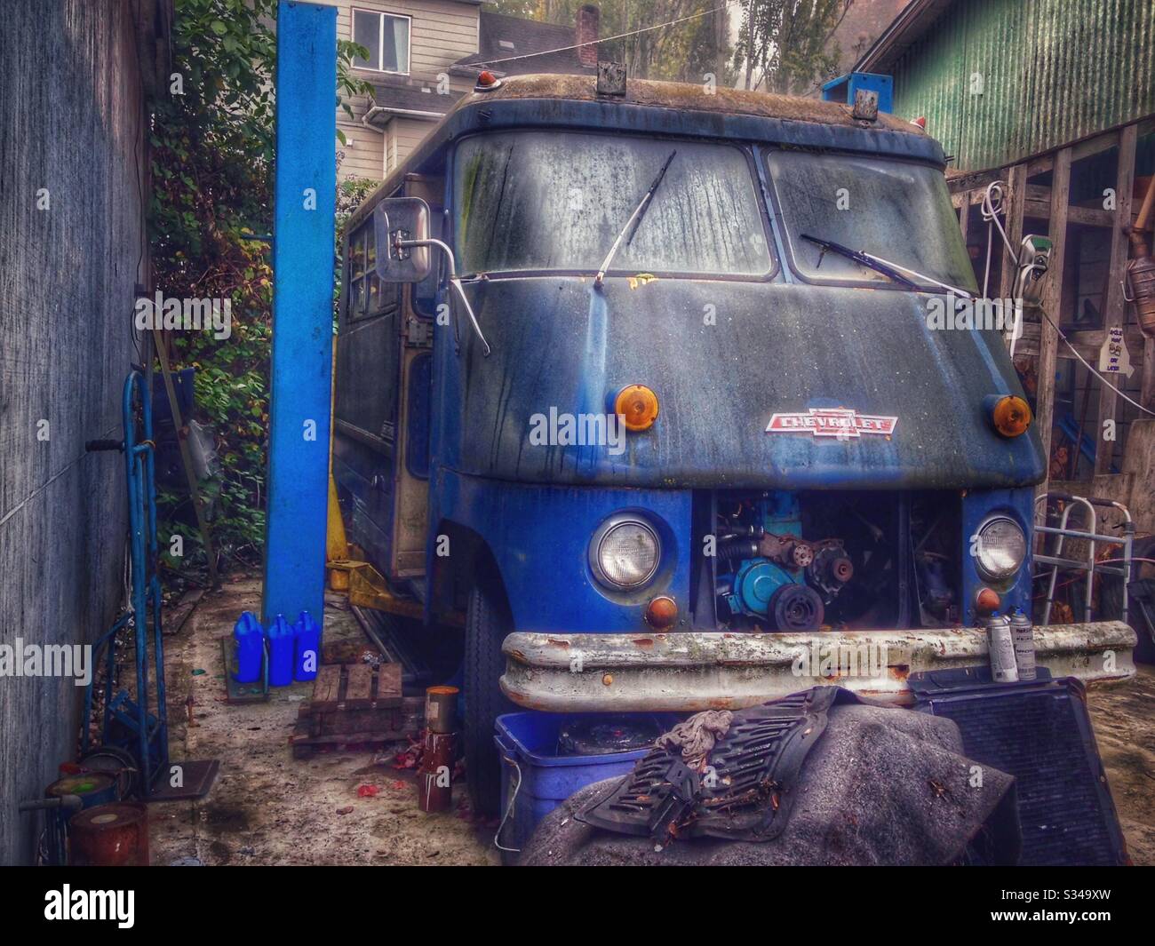 Blue vintage Chevrolet van with split windshield undergoing renovations - Smartphone Captured Stock Image