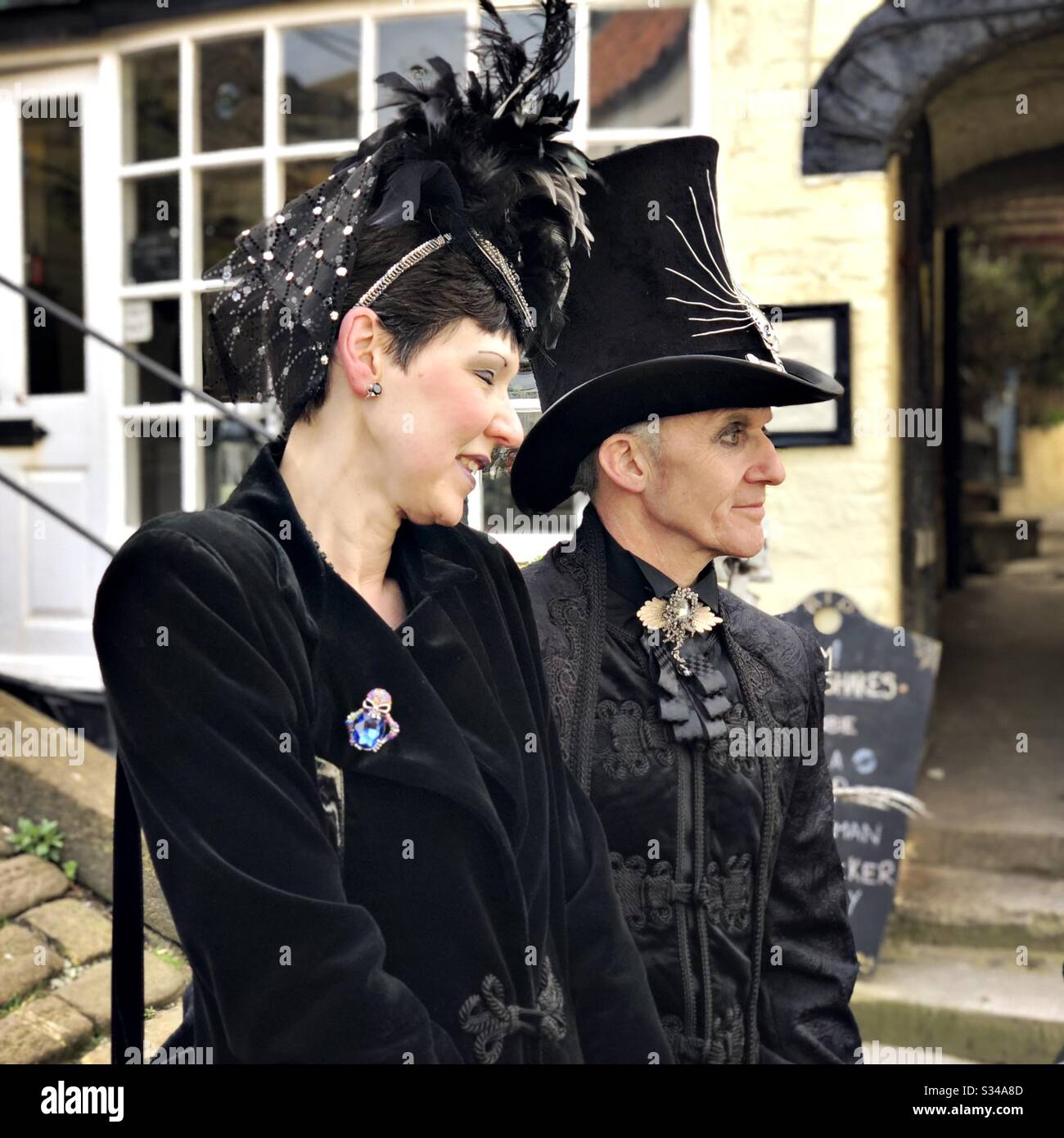 People in creative costumes during a cosplay event. Whitby Goth Weekend. Side profile view of man and woman goth couple Stock Photo