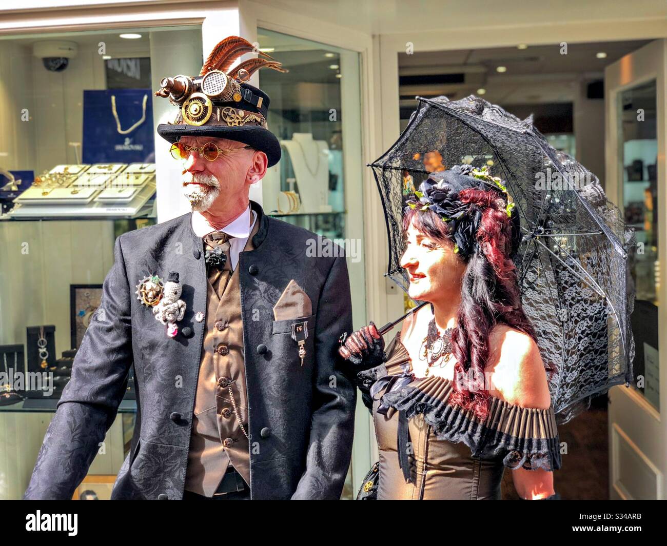 People in creative costumes during a cosplay event. Whitby Goth Weekend. Steampunk man and goth lady - Smartphone Captured Stock Image