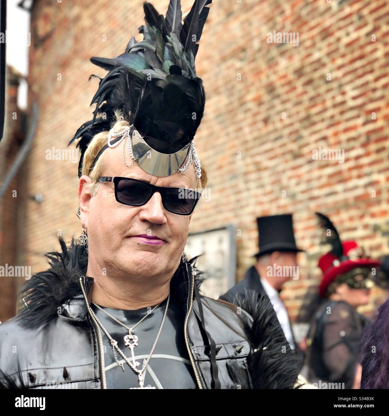 Person in a creative costume during a cosplay event. Whitby Goth Weekend. Portrait of leather goth man - Smartphone Captured Stock Image