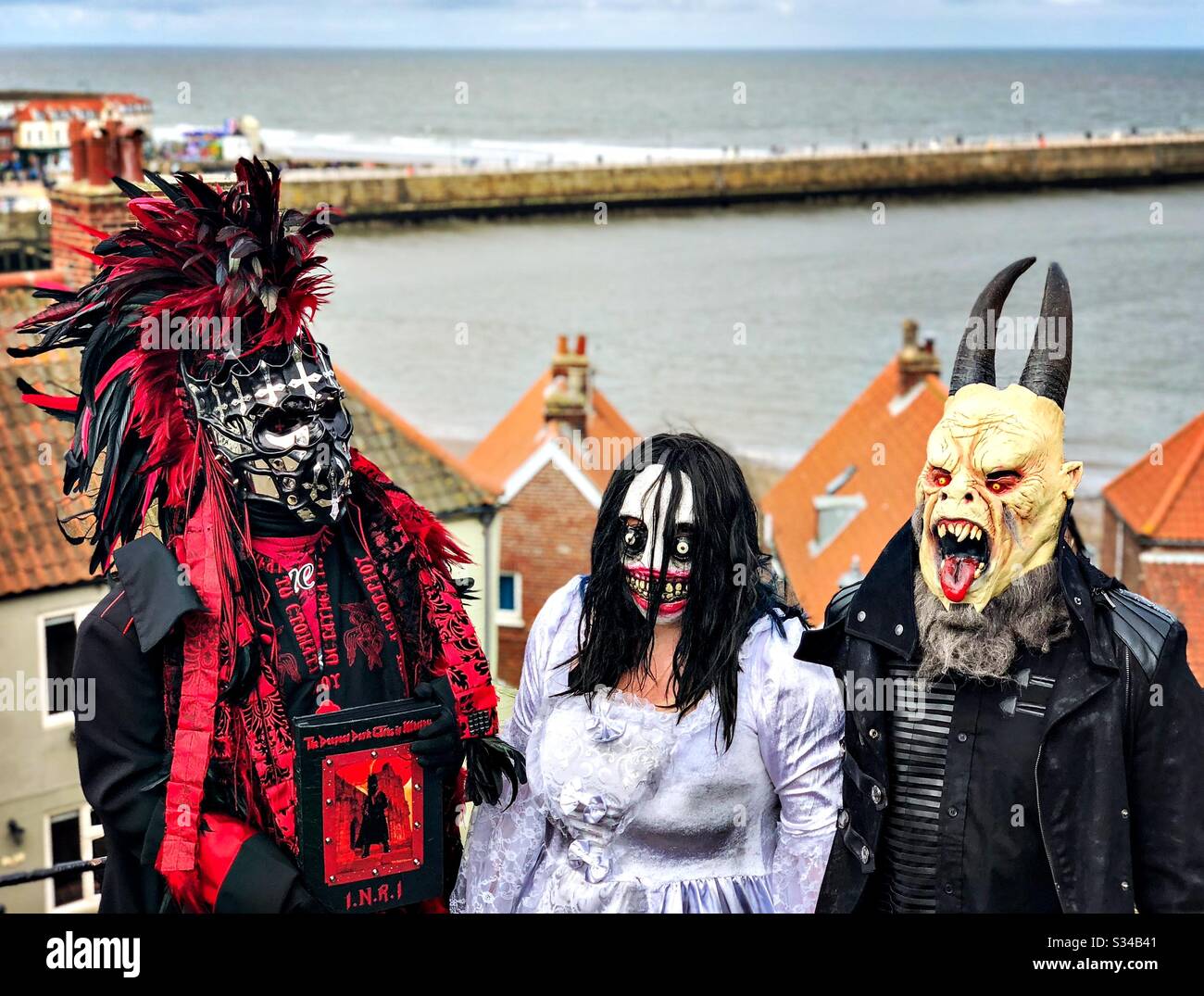 People in creative costumes during a cosplay event. Whitby Goth Weekend. Monster man, woman in street, horror outfits and masks - Smartphone Captured Stock Image