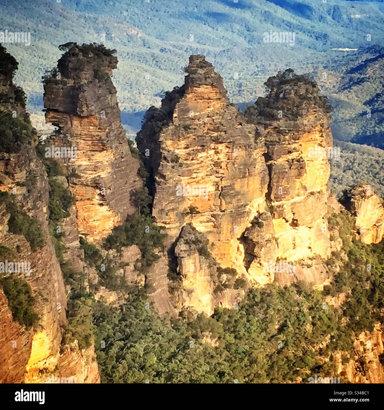 Late afternoon sunlight illuminates the Three Sisters in the Blue Mountains National Park, NSW, Australia - Smartphone Captured Stock Image