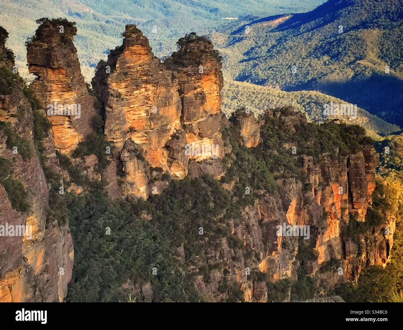 Late afternoon sunlight illuminates the Three Sisters in the Blue Mountains, National Park, NSW, Australia - Smartphone Captured Stock Image
