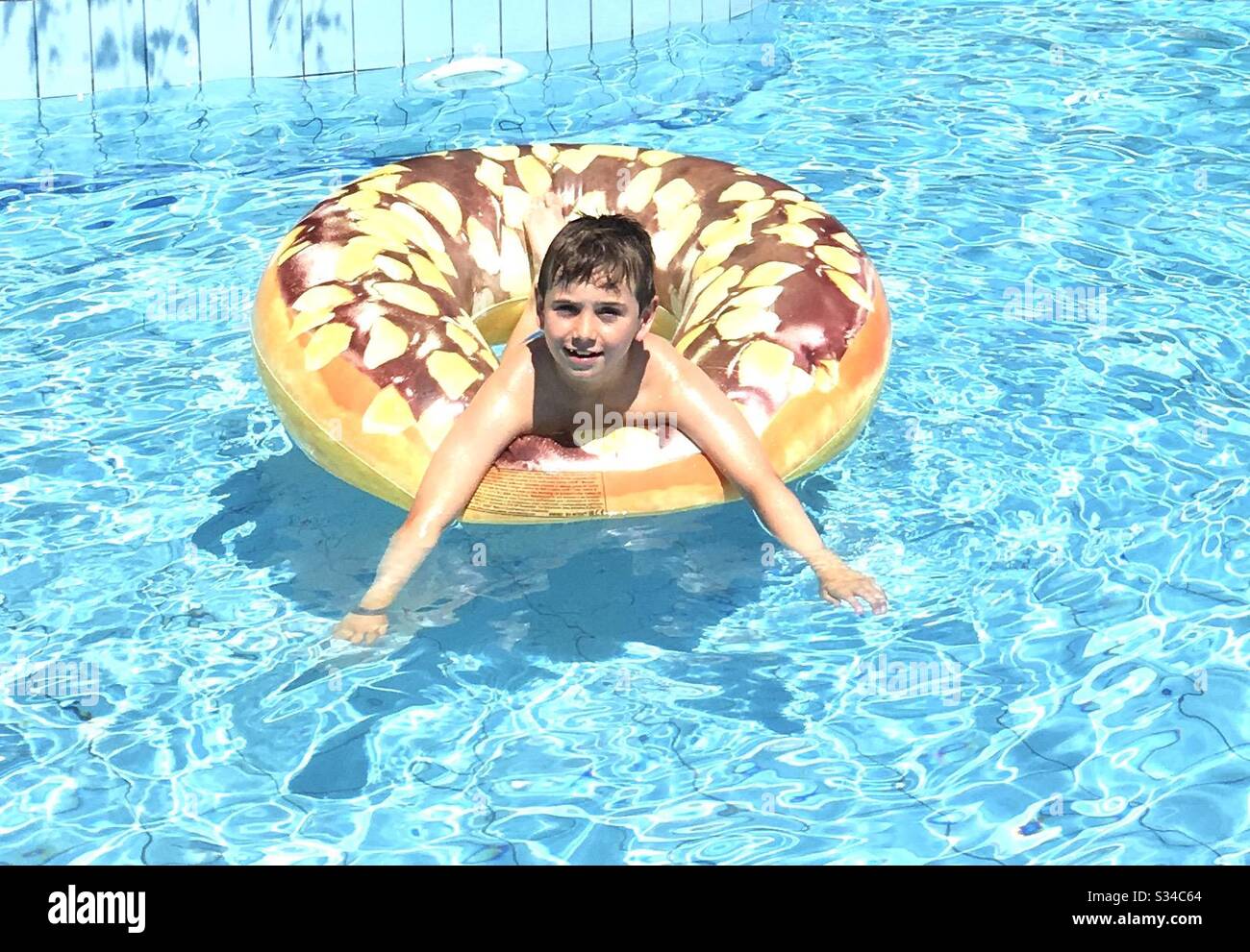 Boy in swimming pool on holiday Stock Photo