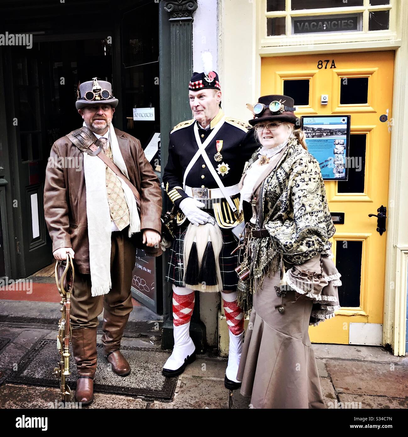 People in creative costumes during a cosplay event. Whitby Goth Weekend. Group of steampunks in Street - Smartphone Captured Stock Image