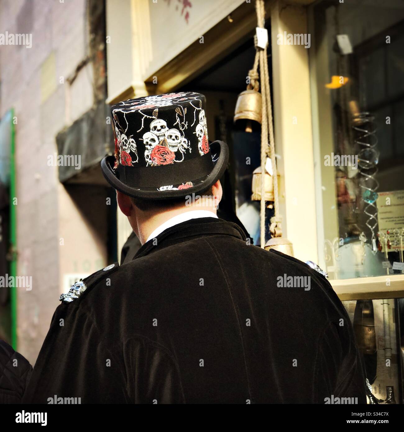People in creative costumes during a cosplay event. Whitby Goth Weekend. Man wears gothic top hat with skull pattern - Smartphone Captured Stock Image