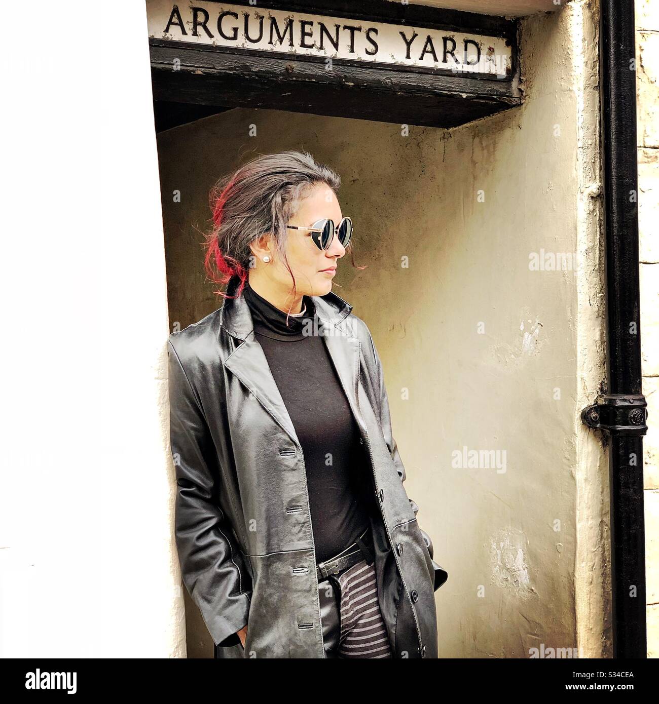 Person in a creative costume during a cosplay event. Whitby Goth Weekend. Steampunk girl in leather jacket and sunglasses - Smartphone Captured Stock Image