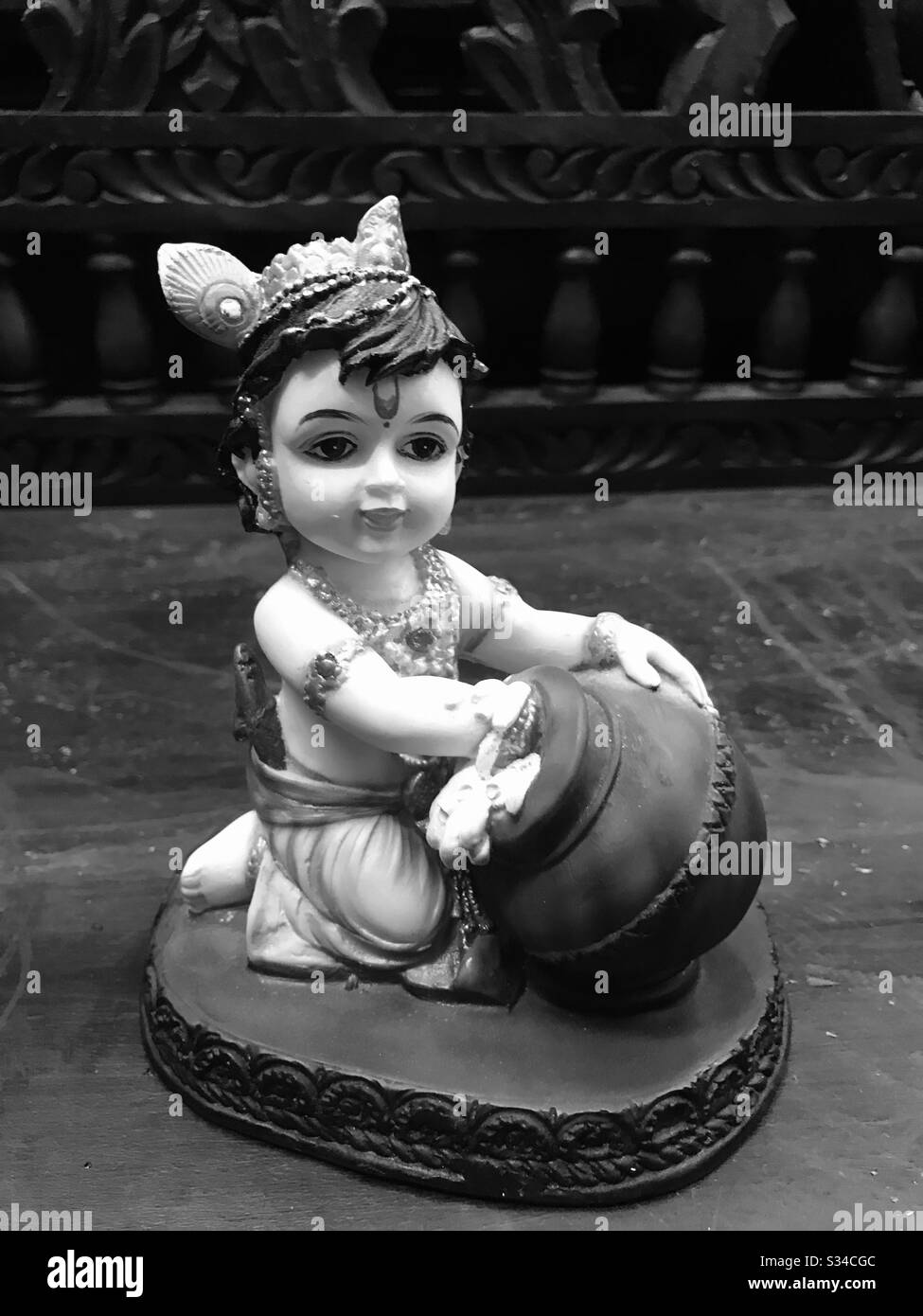 Baby Krishna eating butter- cute small wax statue found In a handicrafts shop in Little India Arcade, Singapore-Hindu God Sri Krishna-Janmashtami-Lord shri Krishnan - Soulful Love of God- Vishu- flute Stock Photo