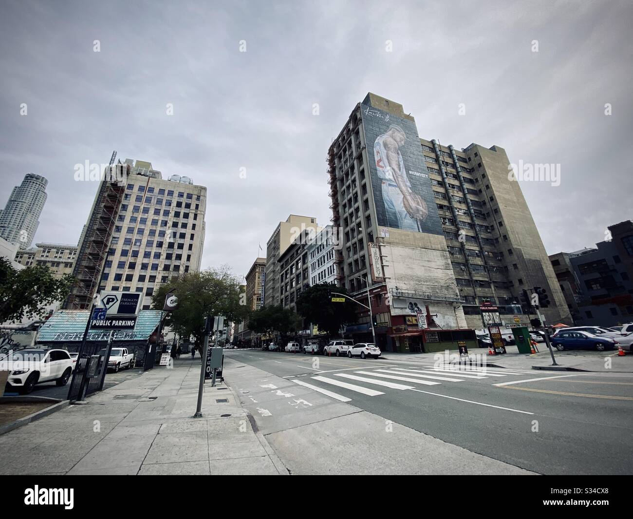 LOS ANGELES, CA, MAR 2020: parking lots, apartments and office buildings on Hill St in Downtown. Mural of Kobe Bryant on nearby building. US Bank Tower visible in background Stock Photo