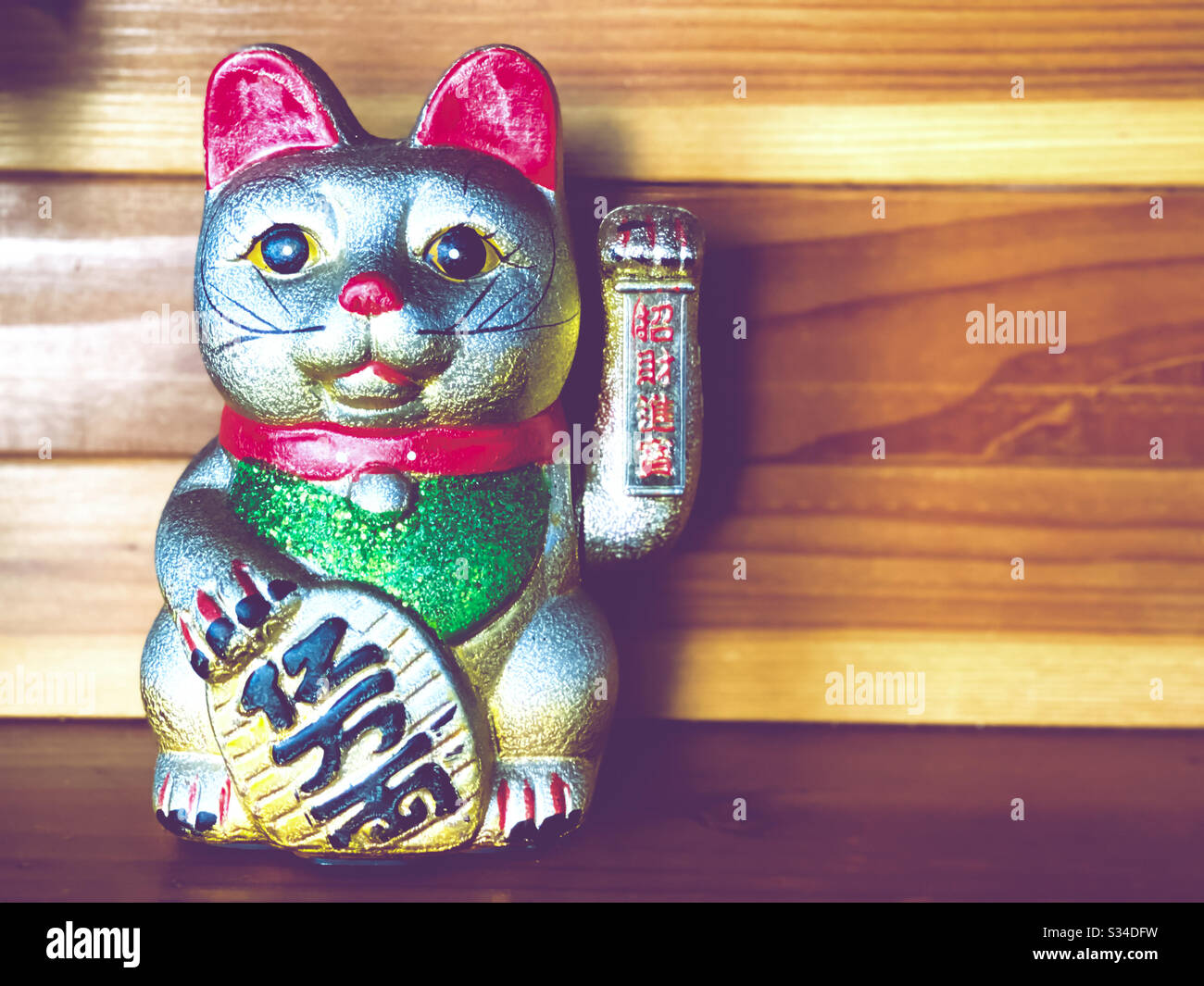 Japanese lucky cat with wood background Stock Photo