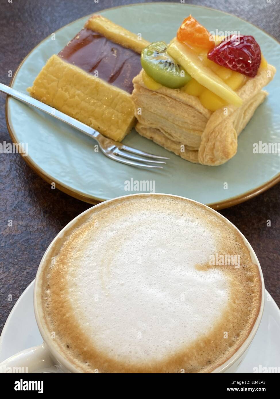 Sweet moment at the bar with colorful pastries and a cappuccino - Smartphone Captured Stock Image