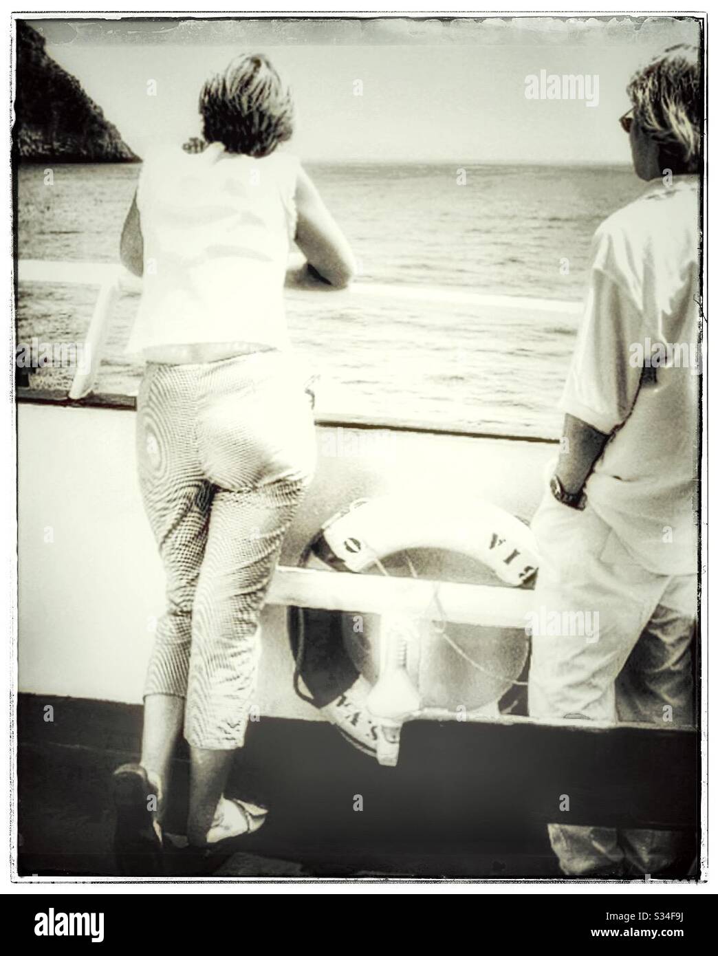 A couple enjoying a sea view from the deck of a boat. - Smartphone Captured Stock Image