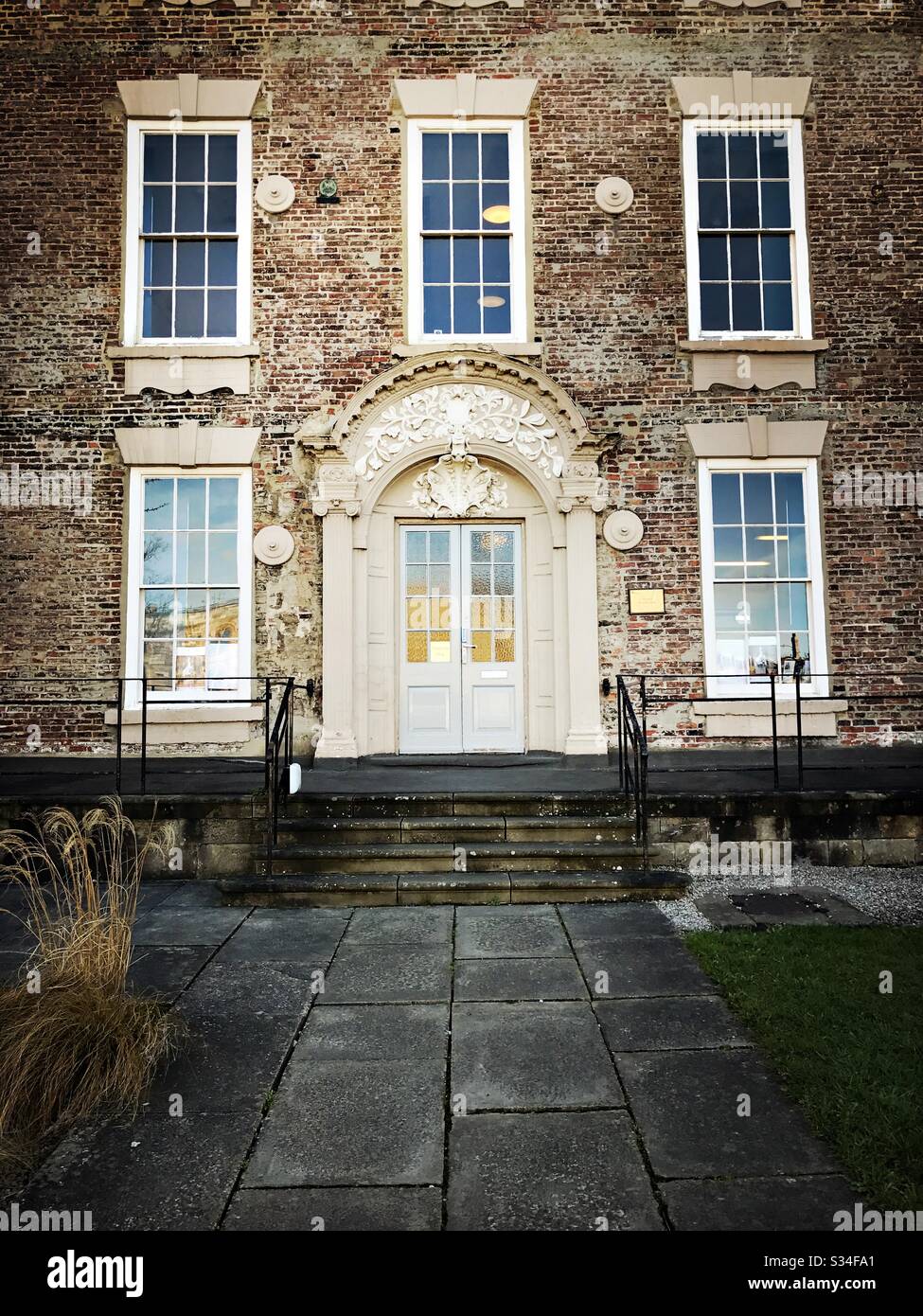 Architecture of Durham City, North East England. Old brick building with stone door surround painted cream and Georgian sash windows. Palace Green. Student buildings - Smartphone Captured Stock Image
