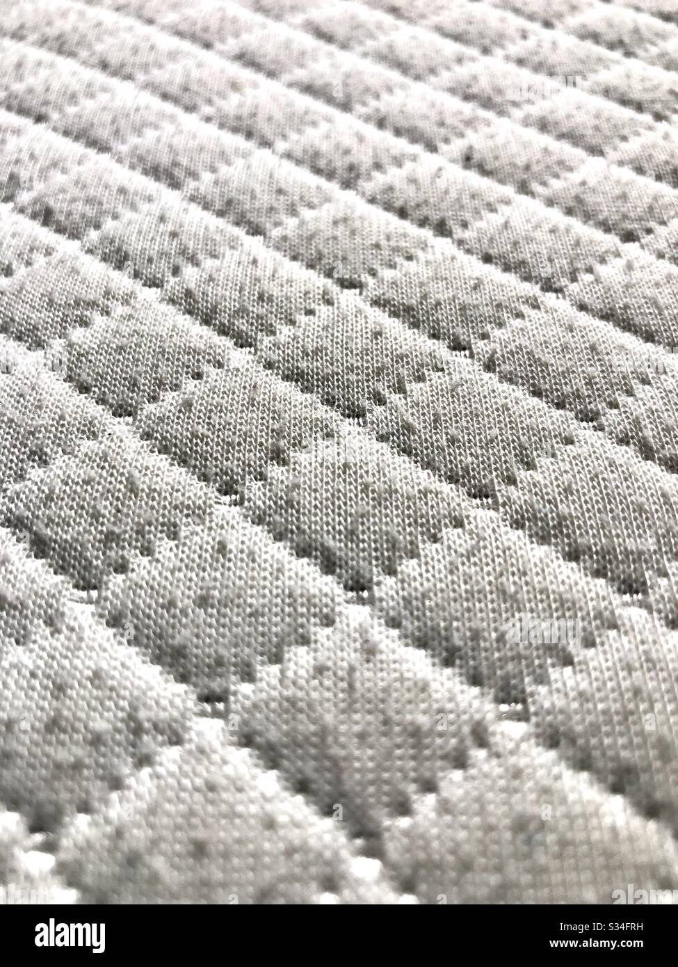 Up close of the texture of a mattress in window light. Stock Photo