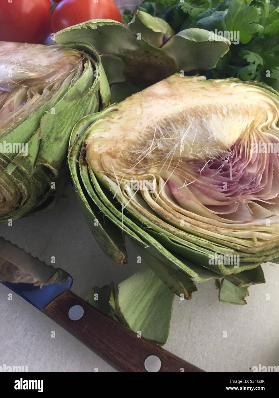 Close up of a cut in half large artichoke on a residential kitchen cutting board, USA Stock Photo
